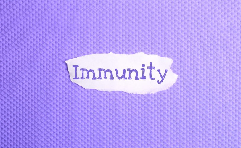 a torn paper written with inscription immunity on a violet background