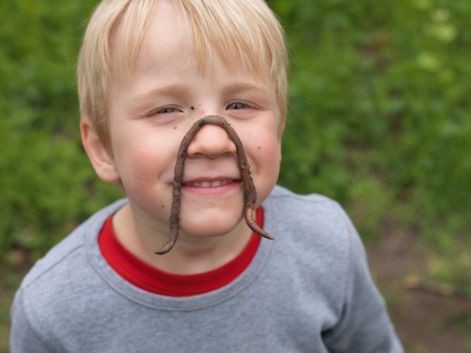 Boys wearing worm on face, portrait