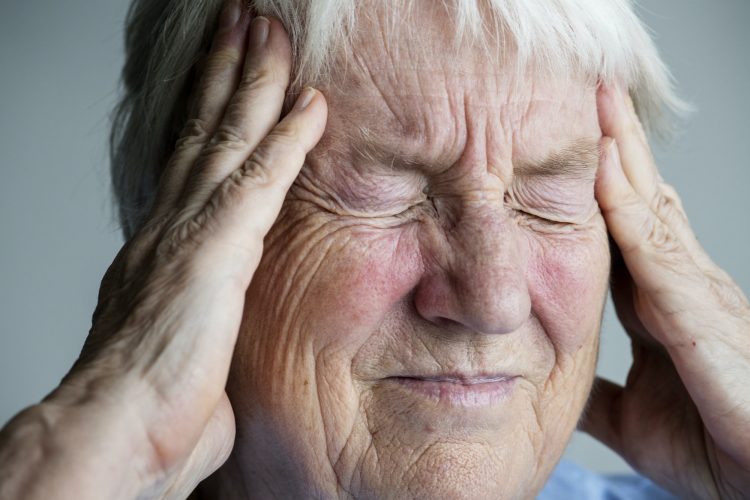 Elderly woman suffering from migraine