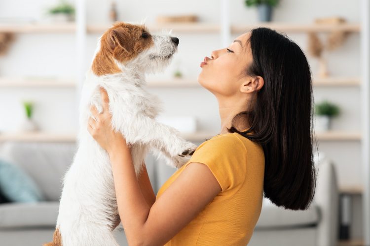 Portrait of loving asian woman carrying her sweet dog