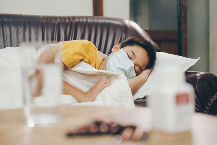 Sick child with high fever laying in bed.