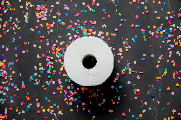 Toilet paper and confetti around on dark background