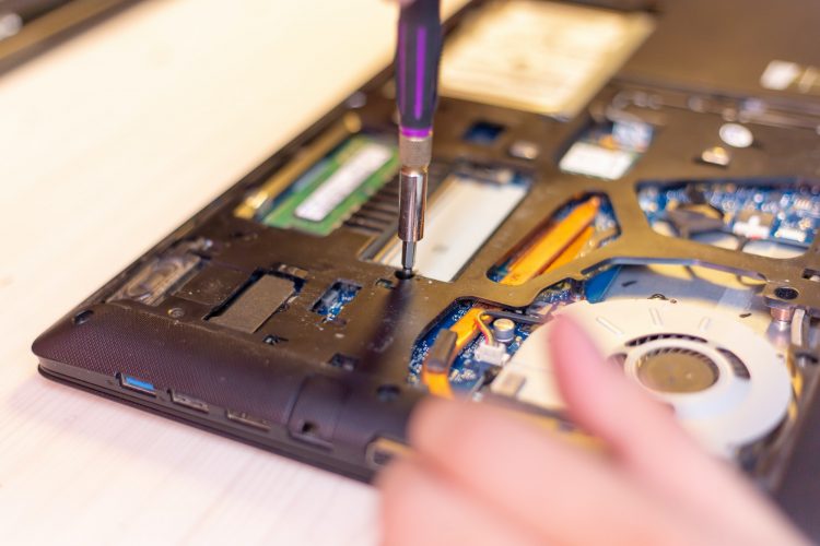 young man hands repare laptop at home
