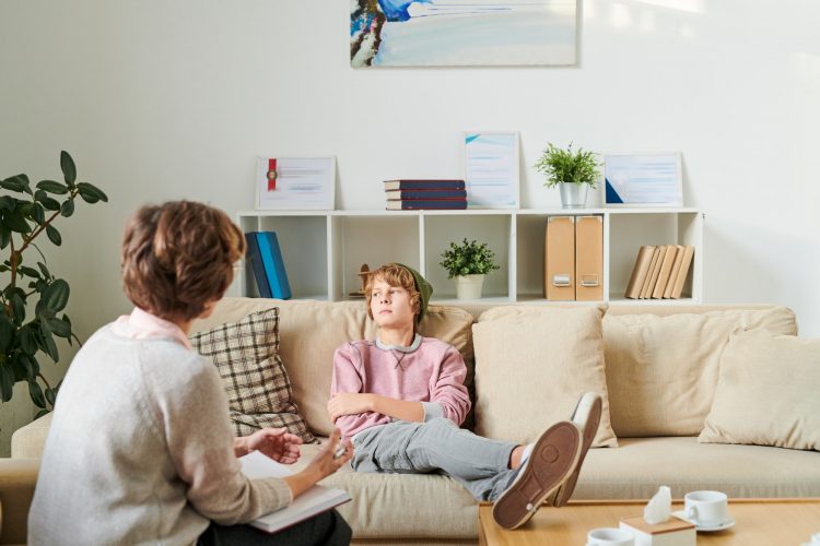 Annoyed boy ignoring psychologist at session