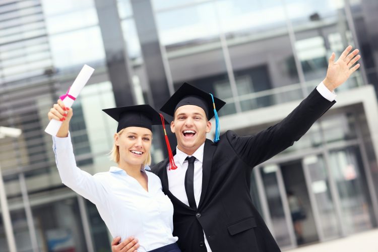 Cheerful graduates outside university