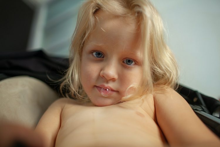 Home morning portrait of a toddler girl with saliva bubble