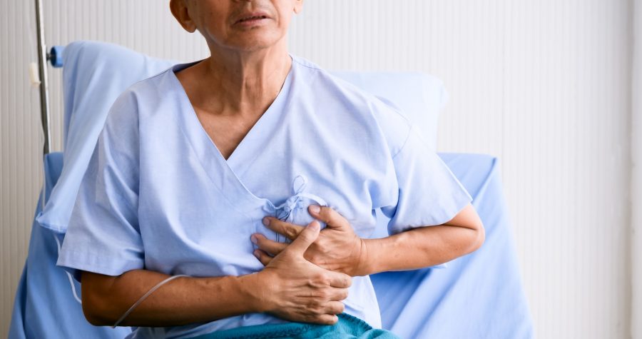 Male patient hasing chest pain on sickbed at hospital room.