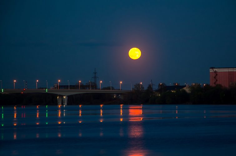 The red moon is reflected in the water