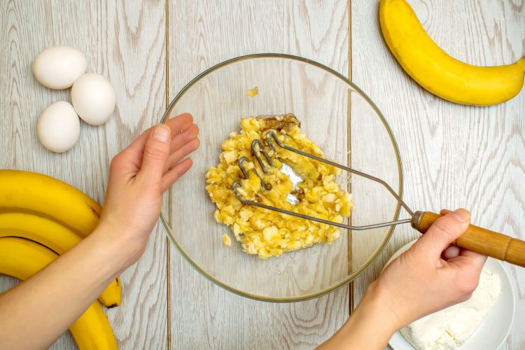 Woman hands mashing up several bananas, cottage cheese to bake into bread,cupcakes. chef cooking