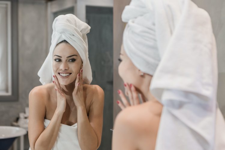 Woman out of the shower massaging her face