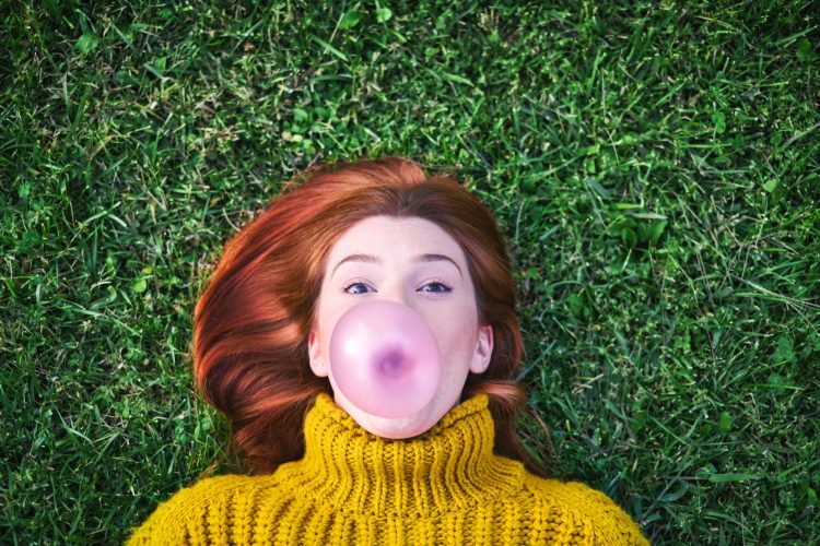 Young Woman Chewing Gum And Making Big Balloon