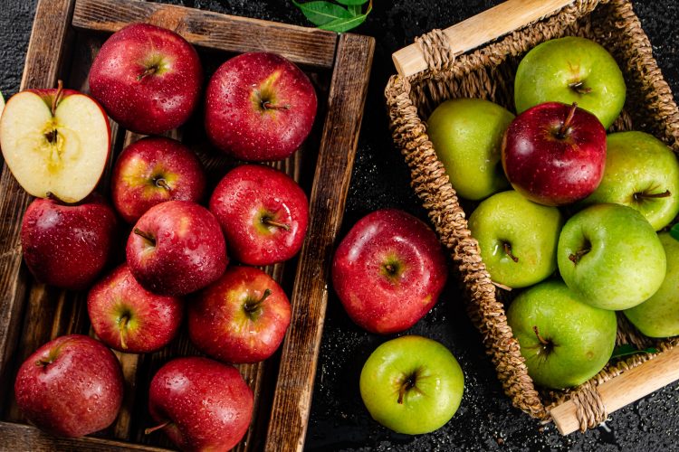 An assortment of red and green apples on the table.