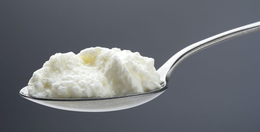 Fresh curdled milk, homemade yogurt in spoon
