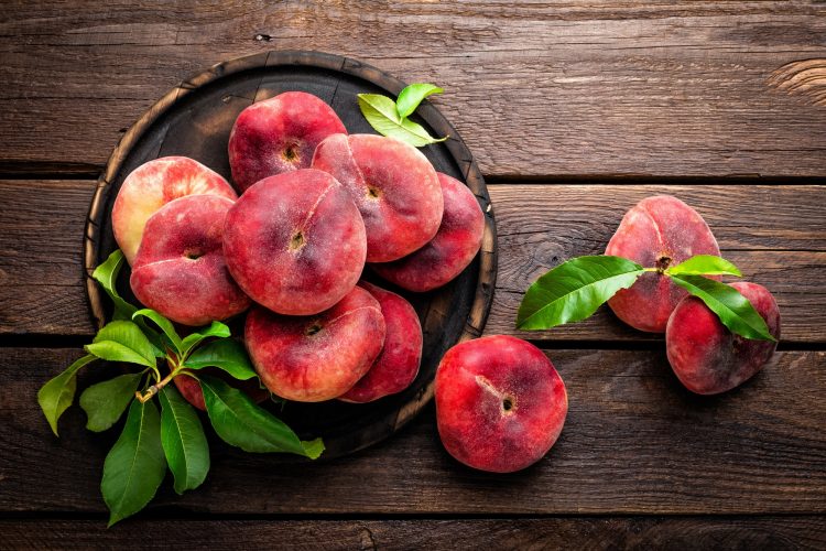 Peach, saturn or donut peaches with leaves