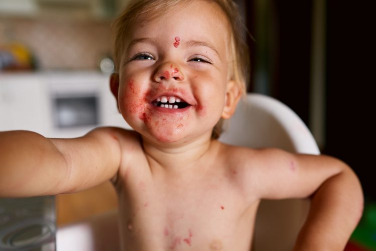 Little laughing child with a dirty face