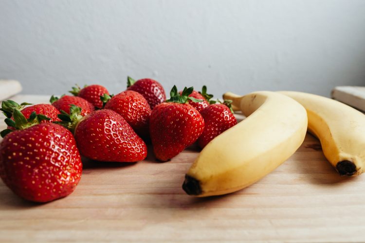 strawberry banana fruits on wood table