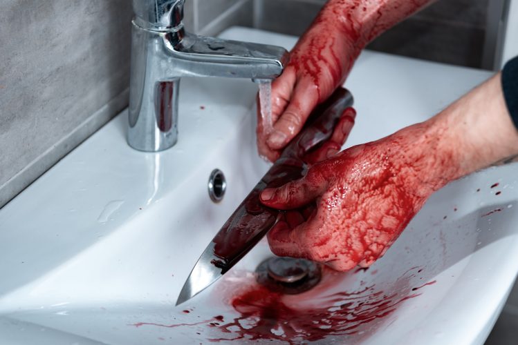 cropped view of killer washing knife in sink after murder