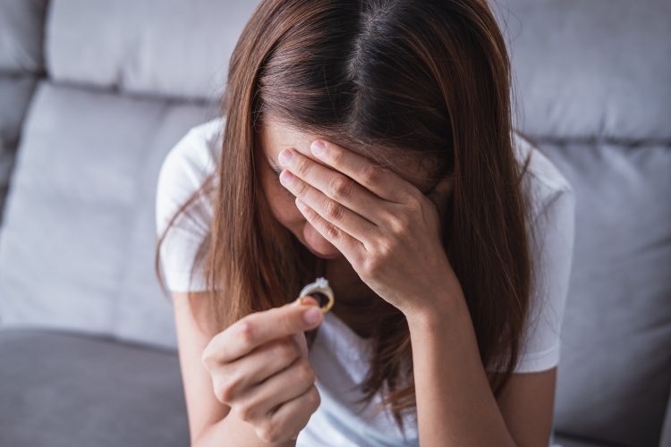 Frustrated sad wife taking off the wedding ring, Young couple breaking up divorce concept