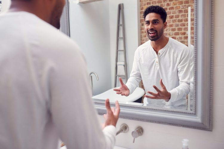Man At Home Practising Giving Speech Or Presentation In Bathroom Mirror