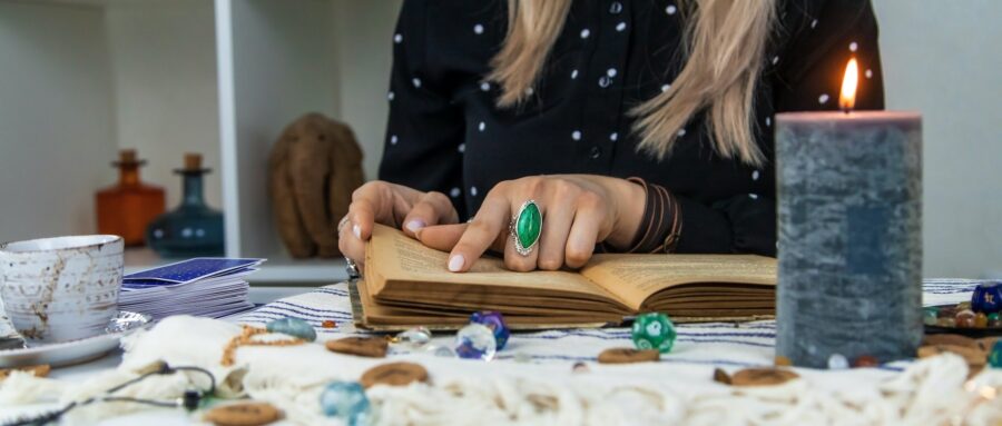 Woman fortune teller reads a book of spells. Selective focus.