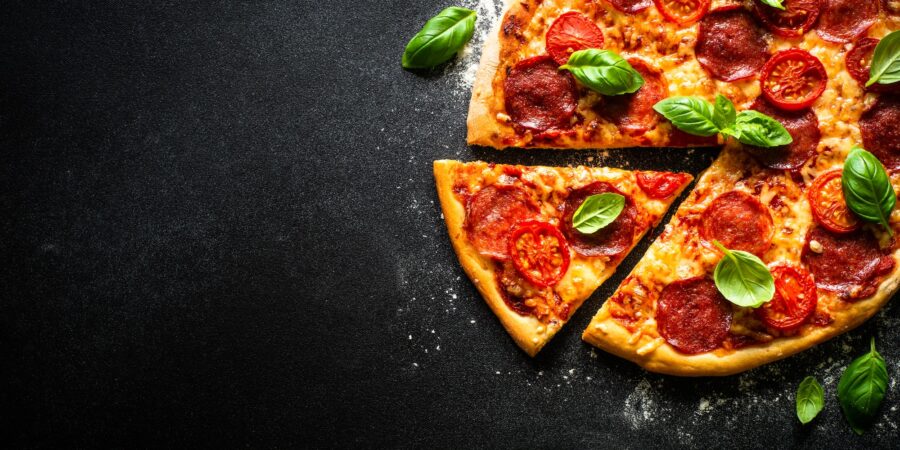 Traditional italian pizza with salami cheese, tomatoes and basil.