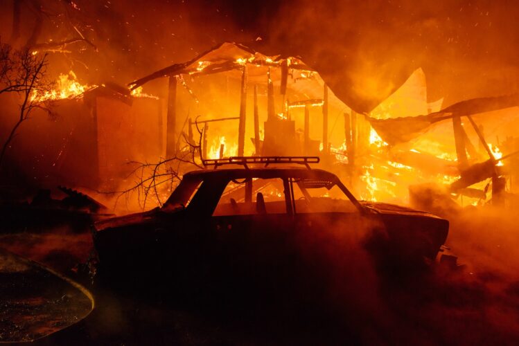 Car and house in smoke and flame destroyed in fire accident