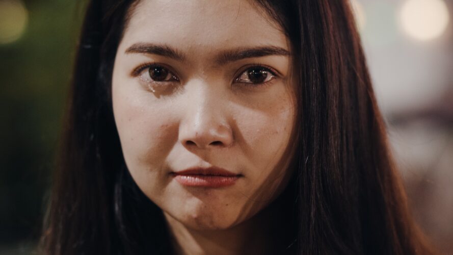 Asian young woman crying depressed in the city.