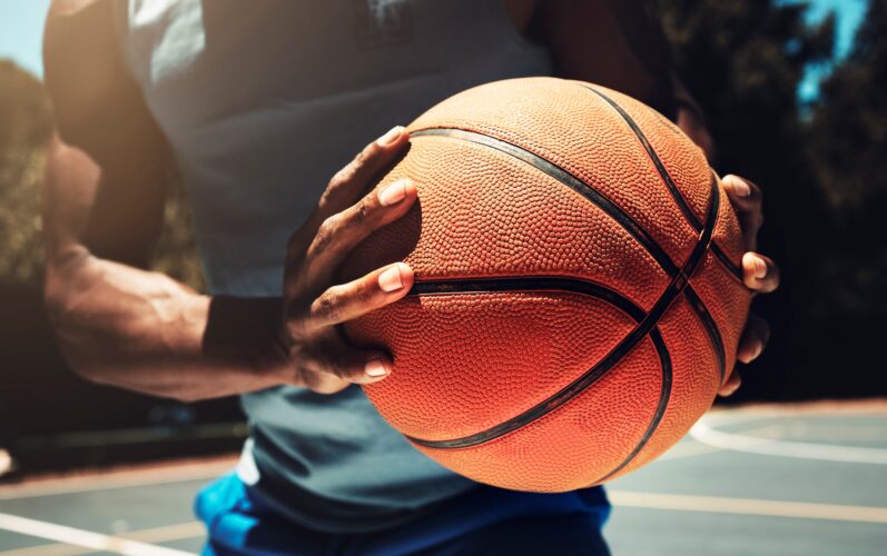 Basketball, basketball player and athlete hands closeup holding ball on basketball court in urban c