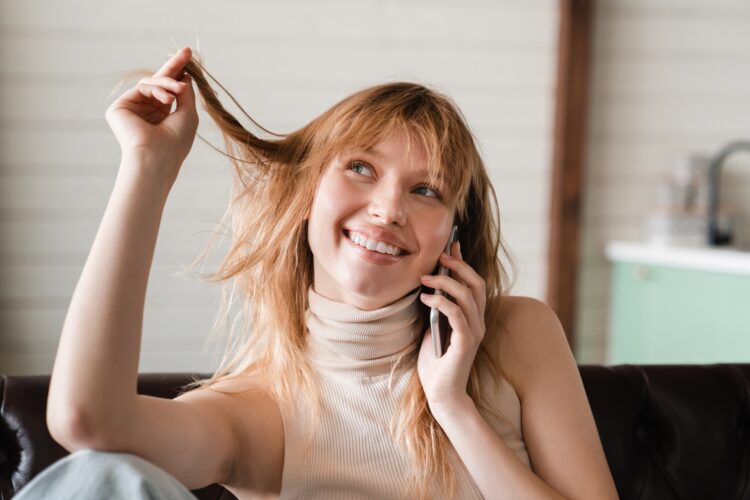 Flirting lovely romantic young woman female student talking on phone with her boyfriend