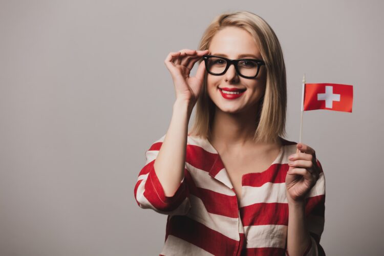 girl holds Switzerland flag on gray backgrou