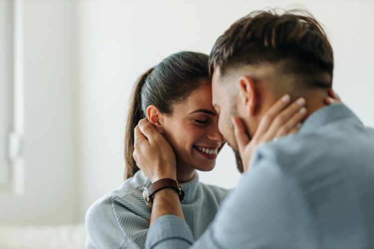 Having a big smile, touching neck.