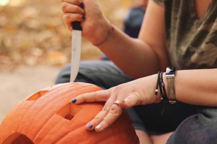A woman carving a pumpkin