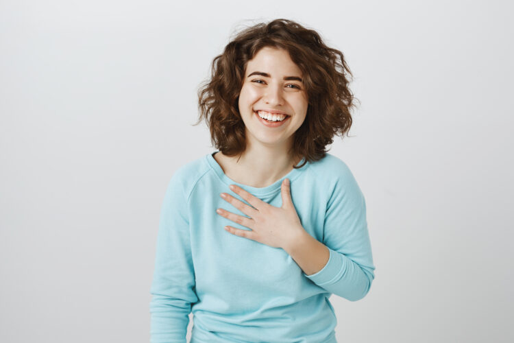 Girl is flatter to bottom of heart. Studio shot of pleased and thankful beautiful caucasian female