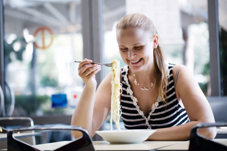 Young woman eating spaghetti