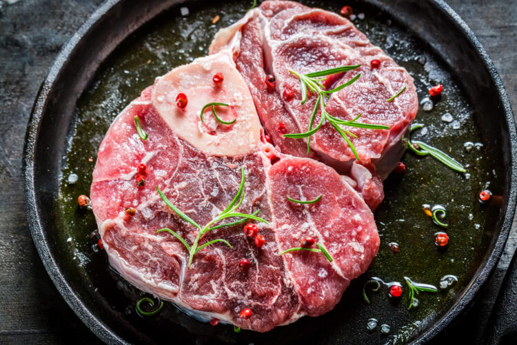 Closeup of red meat with herbs ready for grilling