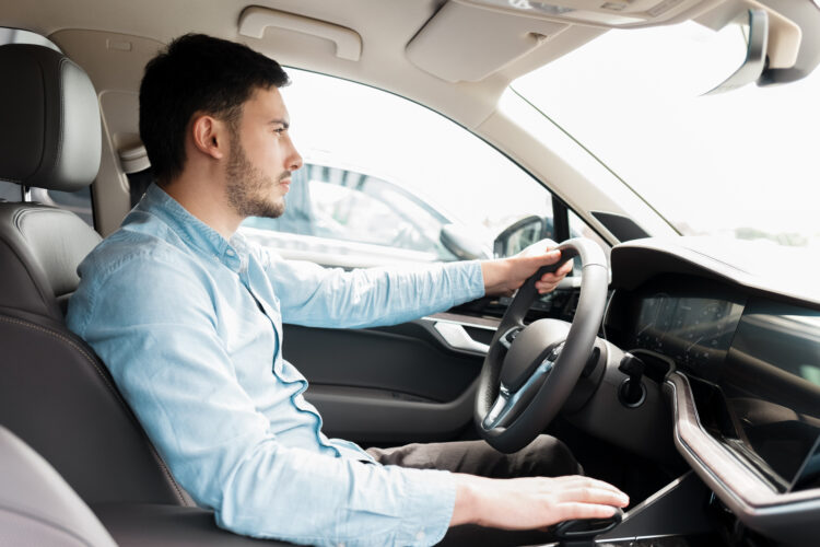 Man driving car. Side view of a man driving an expensive car