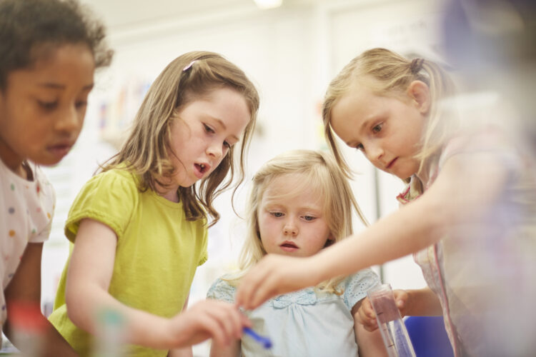 Primary schoolgirls doing experiment in classroom