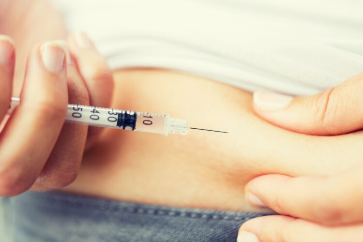 woman with syringe making insulin injection