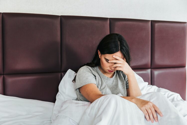 Female lying in bed and having sleeping problems