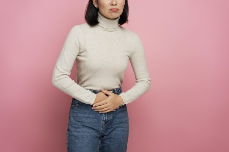 Portrait of woman clutching belly suffering stomach ache, gastritis or constipation