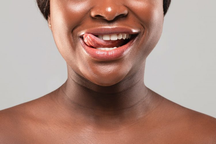 Cropped Image Of Naked Black Female Playfully Biting Her Tongue And Smiling
