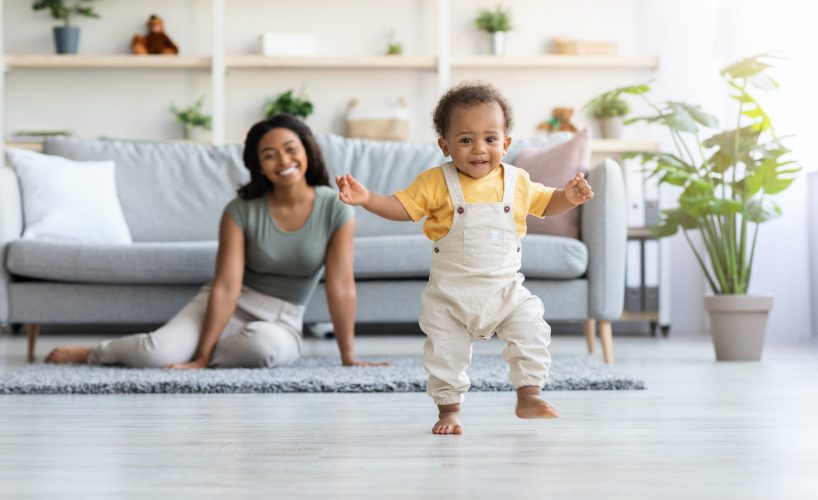 First Steps. Adorable Black Infant Child Walking In Living Room At Home