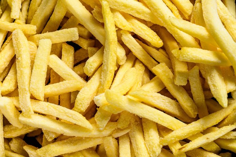 French fries in a frying pan. Gray background. Top view