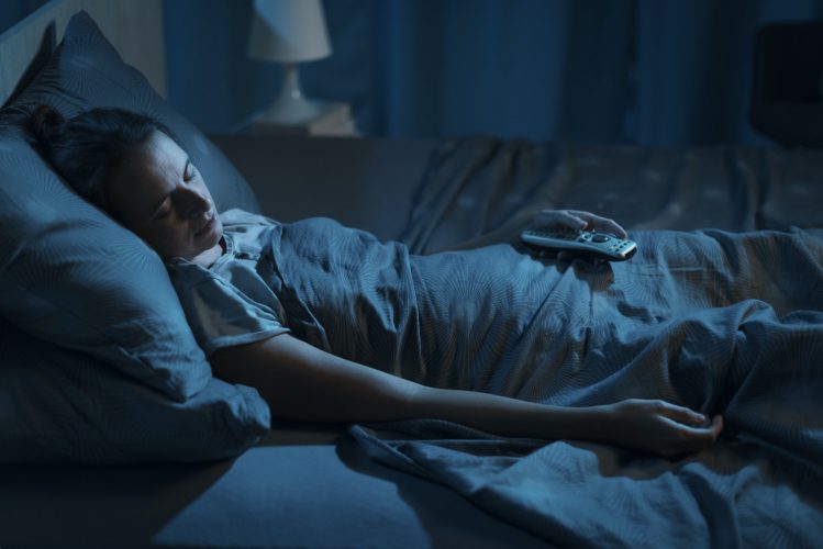Woman sleeping with her TV on