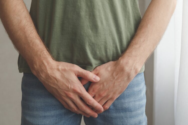 Man cover his groin by hands. Men's health. Urology problems male