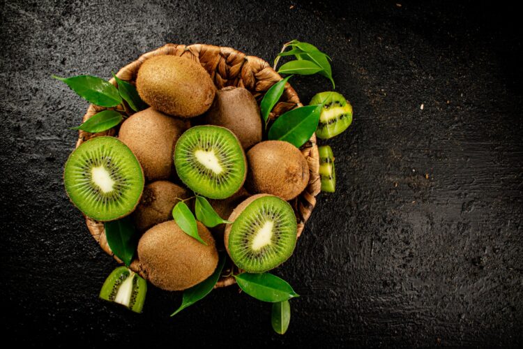 Fresh kiwi with leaves in a basket.