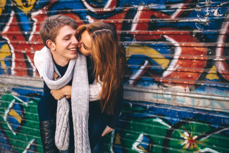 Young girl and boy smiling, hugging each other